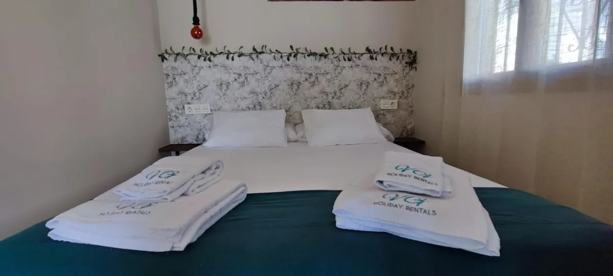Bedroom with queen-size bed and fresh towels
