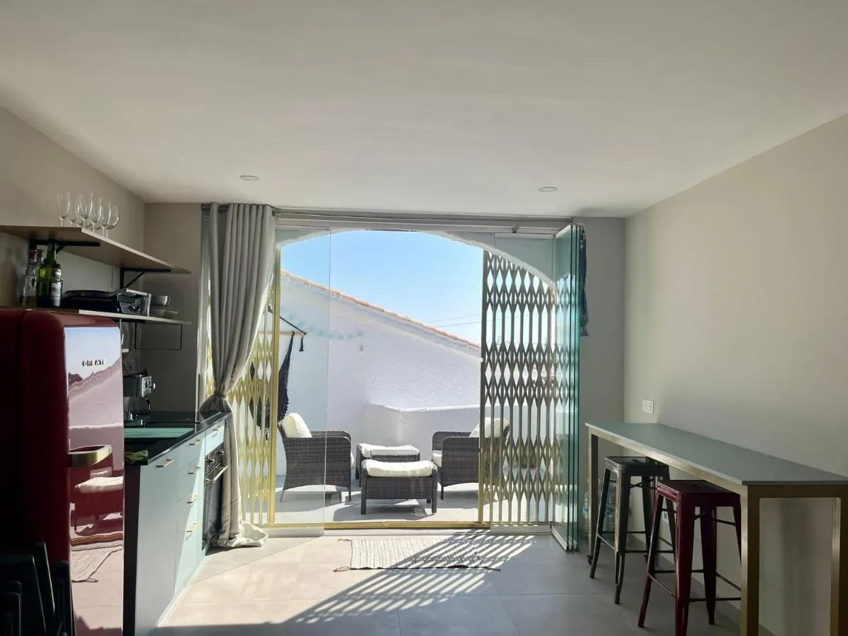 Kitchen opening onto the terrace through an arch