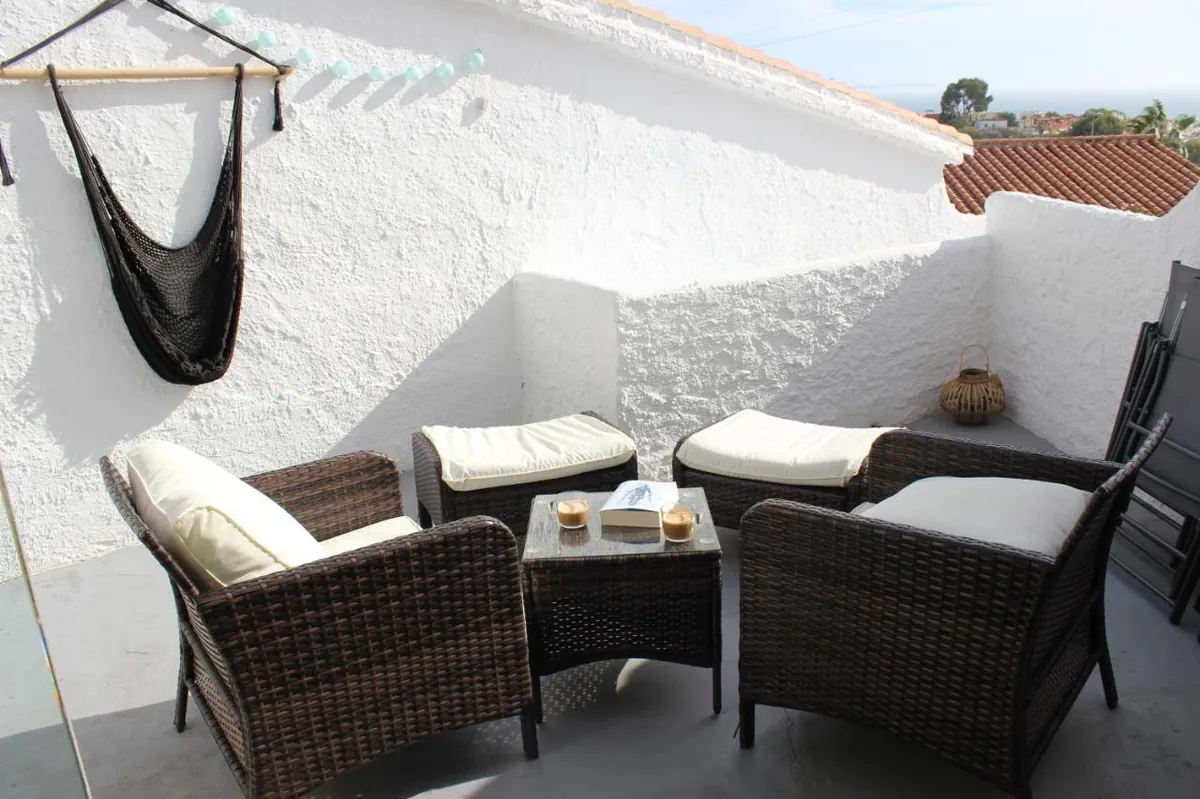 Terrace with hammock and wicker lounge chairs